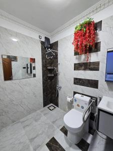 a bathroom with a toilet and a tv in it at Munril Guest in Jaffna +157 photos
