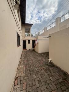 an empty alleyway between two white buildings at Crescent Bud in Durban