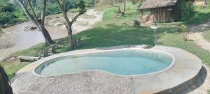 a large pool of water in a yard at At the river campsite in Kihihi +4 photos