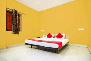 a bedroom with a large bed with yellow walls at Pondy VMB Residency Starlight Hotels in Pondicherry +13 photos