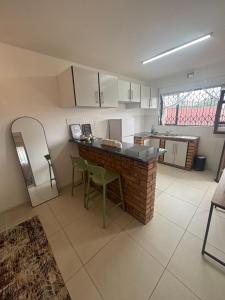 a kitchen with a counter and some chairs in it at Crescent Bud in Durban