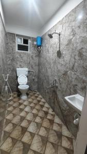 a bathroom with a toilet and a sink at Vandalur Stay's Inn in Vandalūr +9 photos