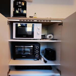 a microwave and a toaster oven on a shelf at FeWo - An Fluss und Weinberg in Briedel