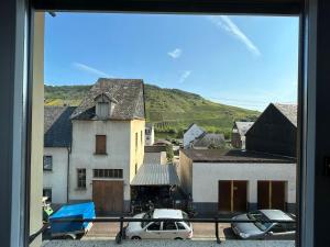 a view from a window of a town with cars parked at FeWo - An Fluss und Weinberg in Briedel