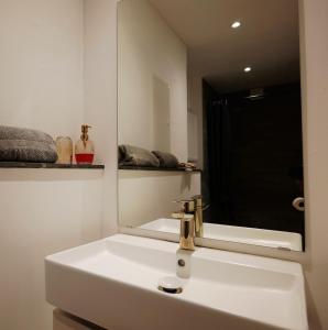 a bathroom with a white sink and a mirror at FeWo - An Fluss und Weinberg in Briedel