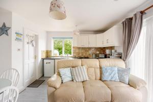 a living room with a couch in a kitchen at Lorna's Apartment Self Catering Holiday Home in Milltown Malbay
