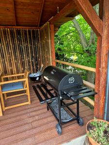 a grill on a porch of a cabin at Riverside Forest Prestige in Chlʼaba