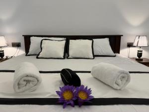 a bedroom with a bed with towels and flowers on it at Wihara Cottage Sigiriya in Sigiriya