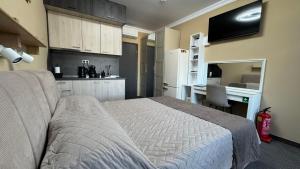 a bedroom with a bed and a desk and a kitchen at Studio Precious in Kranevo