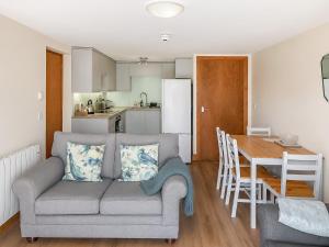 a living room and kitchen with a couch and a table at Howgills Apartment 8 - Ukc9727 in Sedbergh