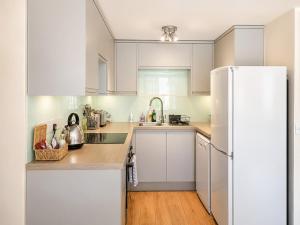 a kitchen with white cabinets and a white refrigerator at Howgills Apartment 8 - Ukc9727 in Sedbergh