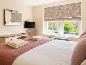 a bedroom with a bed with a desk and a window at Howgills Apartment 8 - Ukc9727 in Sedbergh