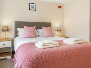 a bedroom with a bed with pink and white sheets at Howgills Apartment 8 - Ukc9727 in Sedbergh +8 photos