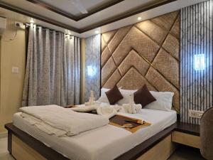 a bedroom with a large bed with white sheets at HOTEL BINAPANI Deluxe 1 in Tarapith