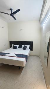 a bedroom with a bed with a ceiling fan at Vandalur Stay's Inn in Vandalūr