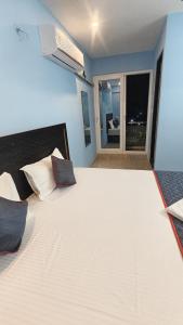 a large white bed in a room with a window at Vandalur Stay's Inn in Vandalūr