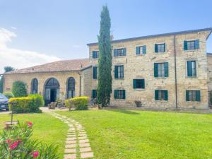 a large stone building with a grass yard at I Costanti in Caldiero