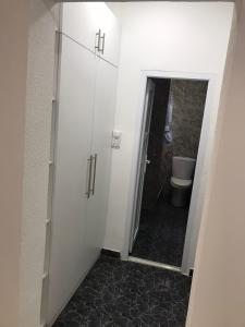 a bathroom with a toilet and a white cabinet at Apartmani Seki in Bar