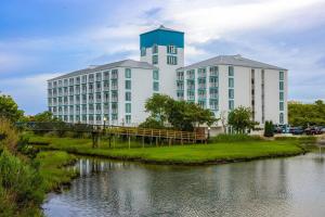 a large white building next to a body of water at Coconut Malorie Resort Ocean City, an Ascend Collection Hotel in Ocean City