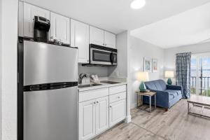 a kitchen with a refrigerator and a couch in a room at Coconut Malorie Resort Ocean City, an Ascend Collection Hotel in Ocean City