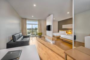 ein Hotelzimmer mit einem Bett und einer Couch in der Unterkunft Hôtel du Lac Champlain, an Ascend Collection Hotel in Venise-en-Québec