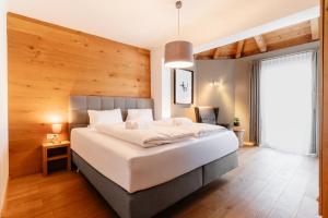 a bedroom with a large bed with a wooden wall at Appartementhaus Reiter in Altenmarkt im Pongau