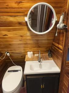 a bathroom with a toilet and a sink and a mirror at Pont NongKhiaw in Nongkhiaw