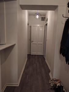 an empty hallway with a door and a room with wood floors at great apartment in Gothenburg