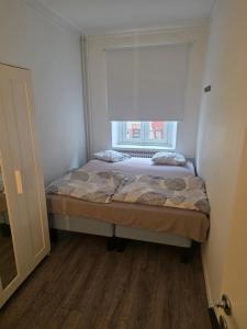 a small bedroom with a bed and a window at great apartment in Gothenburg