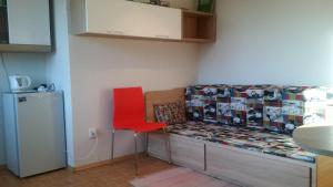 Pokój z łóżkiem z czerwonym krzesłem i lodówką w obiekcie AAprivat Tatry w Świcie