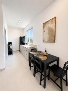 a kitchen and dining room with a black table and chairs at פלג טל -דפנה in Dafna +22 photos