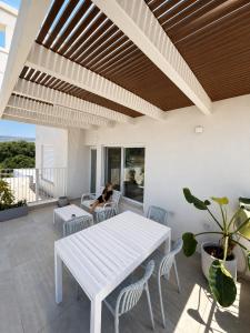 a white dining room with a white table and chairs at פלג טל -דפנה in Dafna