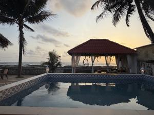 a swimming pool with a gazebo and the ocean at SeaBreeze in Bārsiv