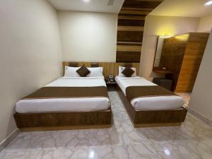 a bedroom with two beds in a room at Hotel Sai Krish Grand Pallavaram in Chennai
