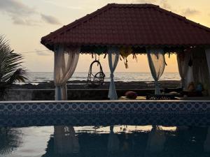 a swimming pool with a gazebo next to the ocean at SeaBreeze in Bārsiv