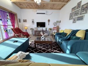 a living room with blue couches and a tv at SeaBreeze in Bārsiv
