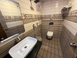 a bathroom with a sink and a toilet at Hotel Sai Krish Grand Pallavaram in Chennai