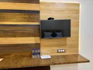 a flat screen tv sitting on top of a wooden wall at Hotel Sai Krish Grand Pallavaram in Chennai
