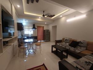 a living room with a couch and a table with chairs at Divin 2BHK Apartments 150 meter to temple in Guruvāyūr