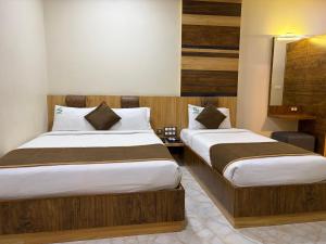 a hotel room with two beds and a mirror at Hotel Sai Krish Grand Pallavaram in Chennai +6 photos