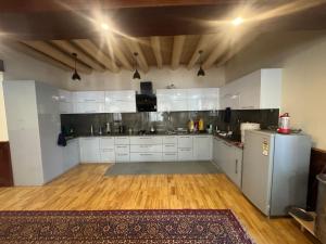 a large kitchen with white cabinets and a wooden floor at Cho Farm House in Leh