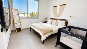 a bedroom with a bed and a mirror in it at פלג טל -דפנה in Dafna