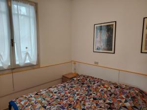 a bedroom with a bed with a quilt on it at le macchie in Lido degli Estensi