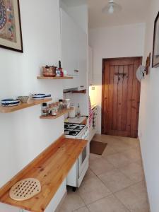 a kitchen with white walls and a wooden counter top at le macchie in Lido degli Estensi