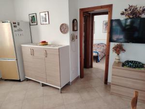 a kitchen with a refrigerator and a room with a bed at le macchie in Lido degli Estensi