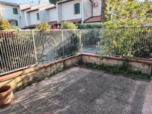 a fence in front of a building next to a building at le macchie in Lido degli Estensi