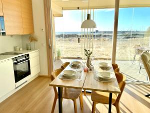 a kitchen with a wooden table with chairs and a dining room at Marina Sunset Resort A2 in Kalajoki