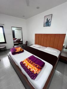 two beds in a room with two robes on them at Jalsa hotel in Raipura