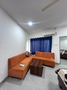 a living room with a brown couch and a table at Jalsa hotel in Raipura +1 photo