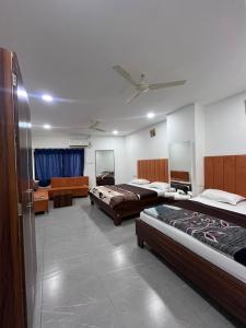 a hotel room with two beds and a couch at Jalsa hotel in Raipura